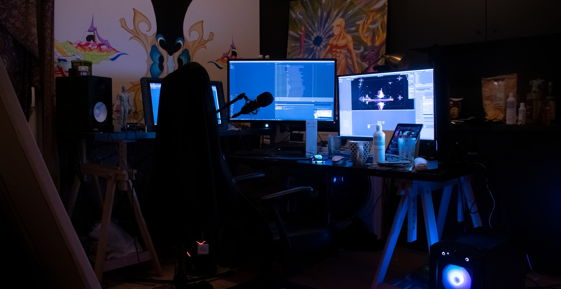 a computer desk with two monitors and a microphone